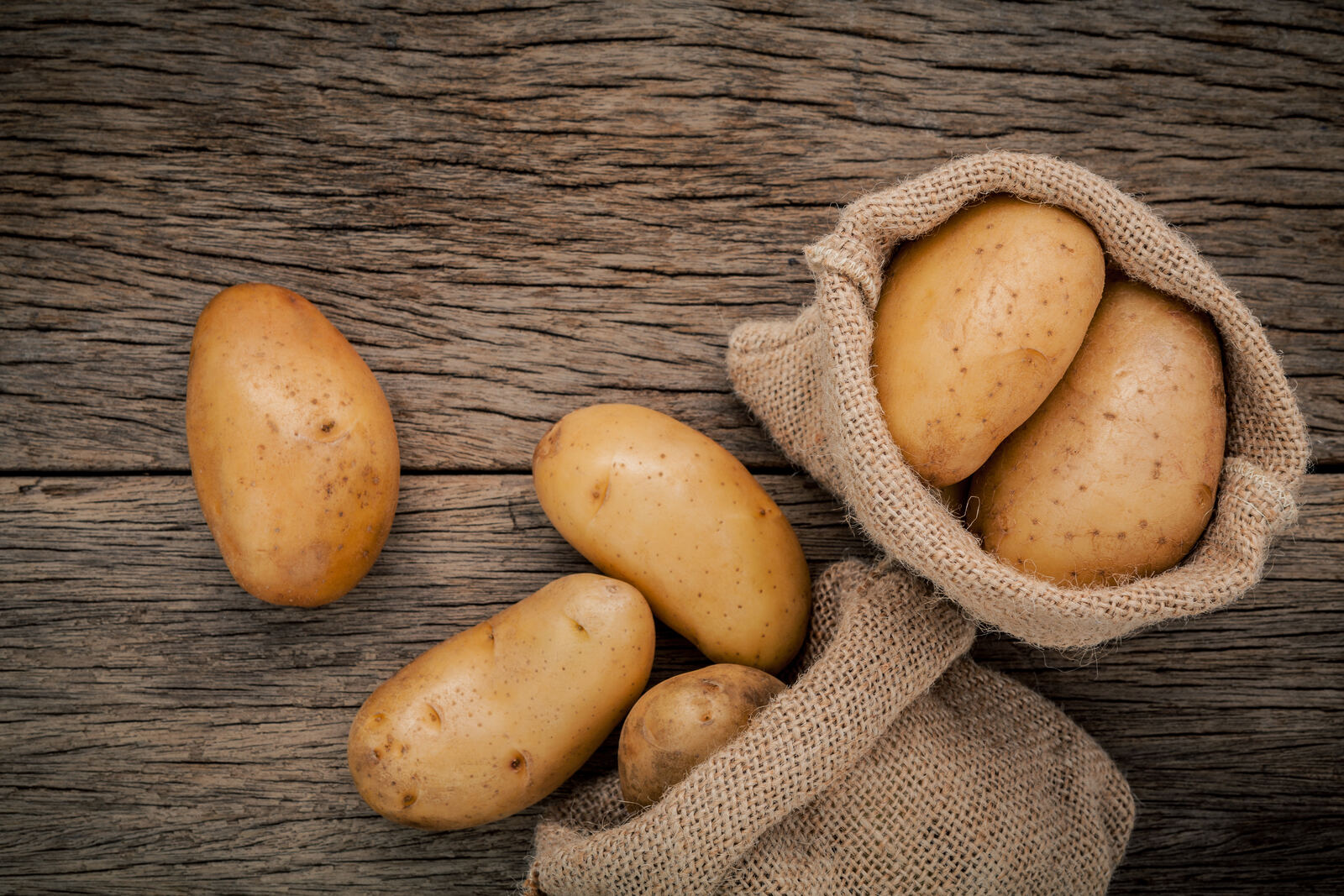 Sacks of potatoes piled on a back porch in early autumn light